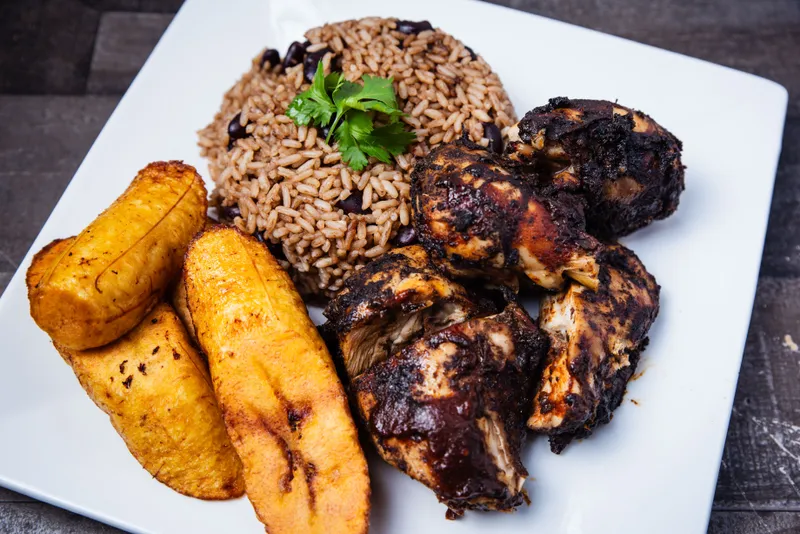 Jerk chicken plate with coconut rice and peas and fried sweet plantain